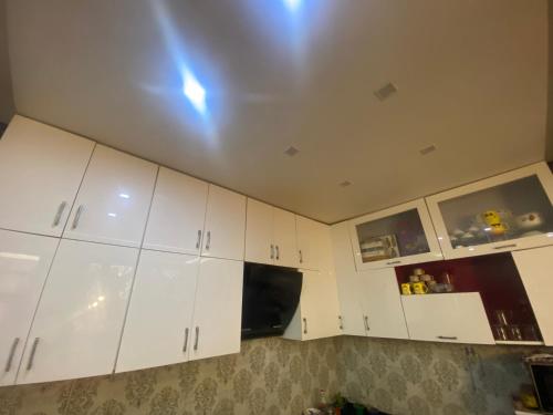 a kitchen with white cabinets and a ceiling at Aatri Estate in Jabalpur