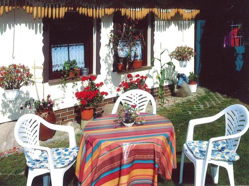 a table with two chairs and a table with flowers at Bungalow in Lübben with a terrace in Lübben