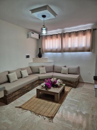 a living room with a couch and a table at Cozy Apartment in Monastir