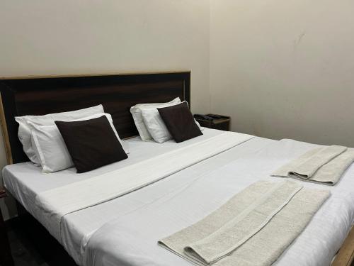 a large white bed with two pillows and towels on it at Braj NIDHIVAN dham in Jāmb