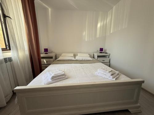 a bed in a bedroom with two towels on it at Central Apartament -Târgu Ocna in Tîrgu Ocna
