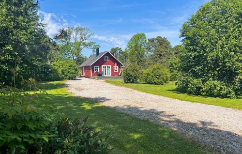 a red house with a gravel road in front at Lovely Home In Gotlands Tofta With Wifi in Hejde