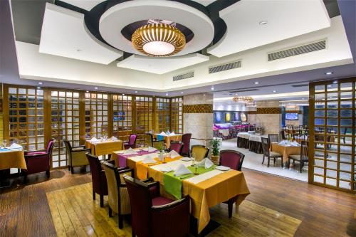 a restaurant with tables and chairs and a chandelier at Bengal Blueberry in Dhaka