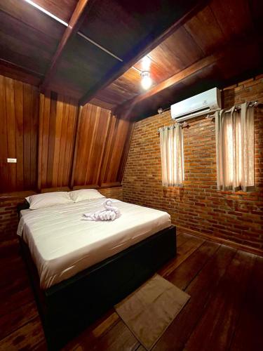 a bed in a room with a brick wall at Soluta Resort in Wainapal