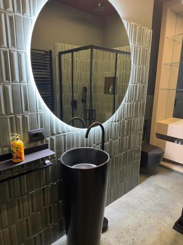 a bathroom with a round mirror and a bucket at Flat in Duomo in Milan