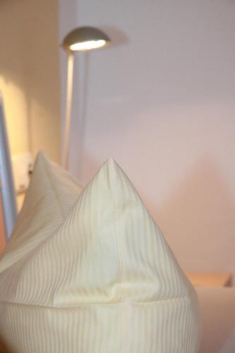 a white pillow sitting on a table with a lamp at Ferienwohnungen Holder in Anhausen