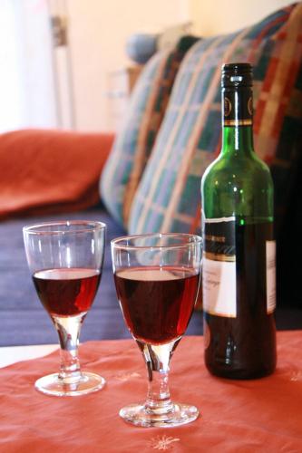 two glasses of wine and a bottle on a table at Ferienwohnungen Holder in Anhausen