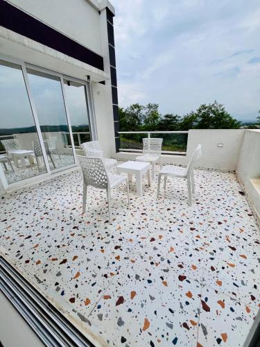 a patio with chairs and tables on a balcony at Krushnai Akshay Villa - Neral in Vangani