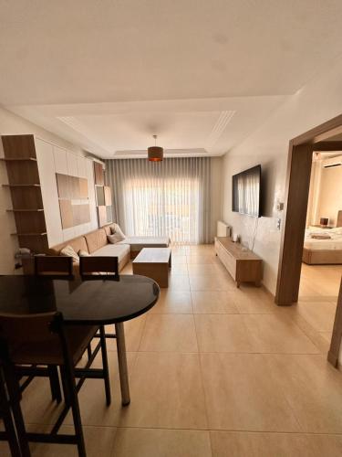 un ampio soggiorno con divano e tavolo di Palm Lake Resort - Appartement terrasse a Monastir