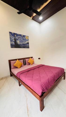 a large bed with pink sheets and yellow pillows at RKS- The Studio Farm in Valap