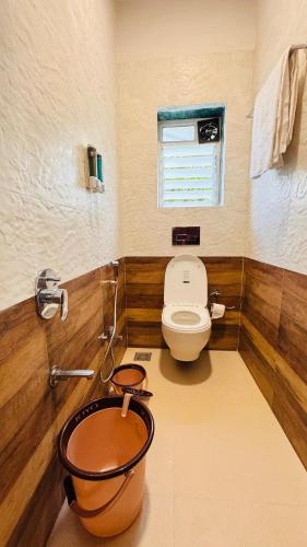 a bathroom with a toilet and a sink in it at RKS- The Studio Farm in Valap