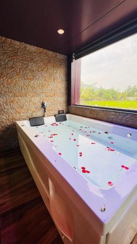 a large bath tub in a room with a window at RKS- The Studio Farm in Valap