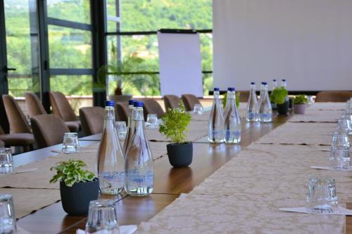 a long table with wine bottles and plants on it at Park Lakeside Ohrid in Ohrid
