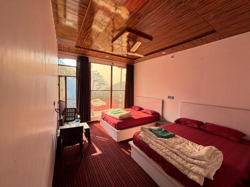 deux lits dans une chambre avec une fenêtre dans l'établissement kedar hill resort, à Sonprayag