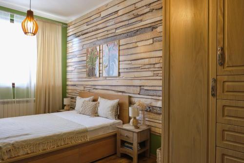 a bedroom with a bed and a wooden wall at Premier Luxury Apartment Center Gabrovo in Gabrovo