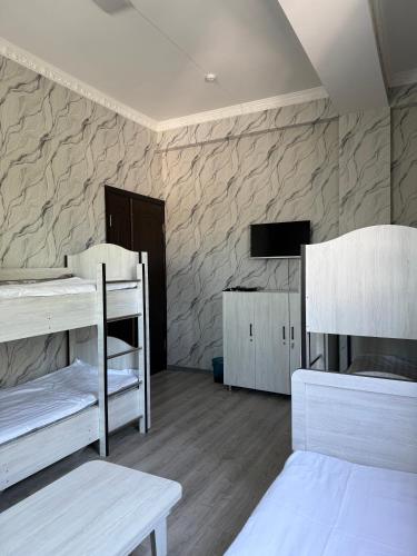 a room with two bunk beds and a tv at Chorsu Old City in Tashkent