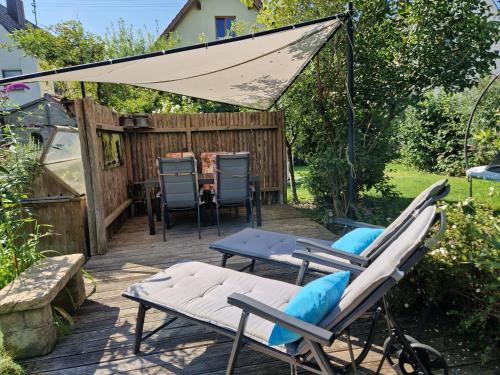 a patio with chairs and a table and a tent at See-Moment-Appartment in Augsburg