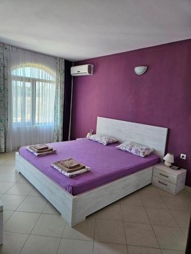 a bedroom with purple walls and a large bed at Lozenets Oasis Beach Home Lila in Lozenets