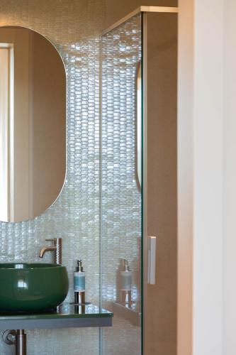 a bathroom with a green sink and a mirror at Villaggio Narrante - Cascina Galarej in Serralunga d'Alba
