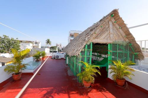 a building with a roof with plants on a balcony at La Maison Radha in Puducherry