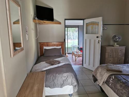 a bedroom with a bed and a tv on the wall at Zonneblom Guest House in Middelburg
