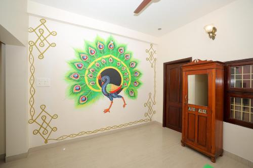 a room with a peacock mural on the wall at La Maison Radha in Puducherry