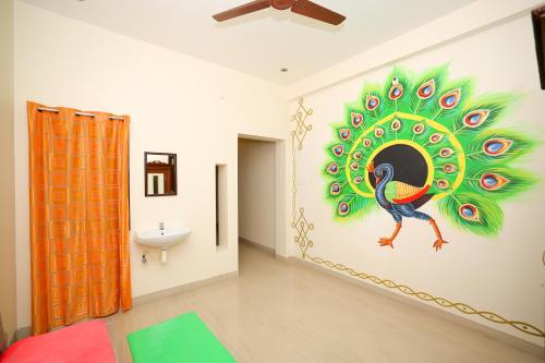 a bathroom with a peacock painting on the wall at La Maison Radha in Puducherry