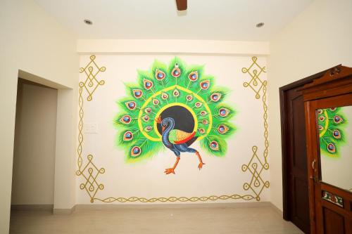 a painting of a peacock on a wall at La Maison Radha in Puducherry