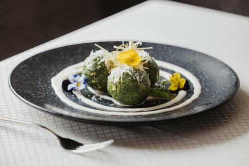 a plate of food with flowers on a table at Hotel Melodia del Bosco in Badia