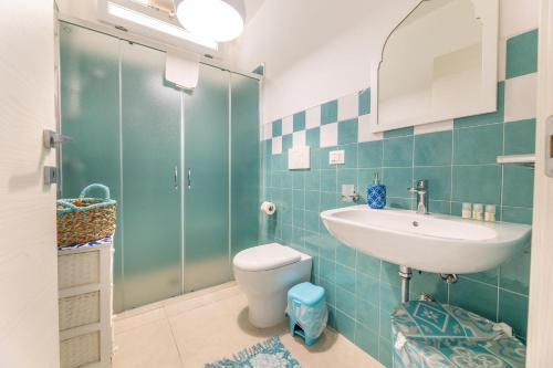 a bathroom with a toilet and a sink and a shower at Appartamento Playa Lapillo in Nardò
