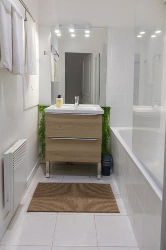 a bathroom with a sink and a mirror at La Perle - Jacuzzi - Wifi - Parking PV in Lunel