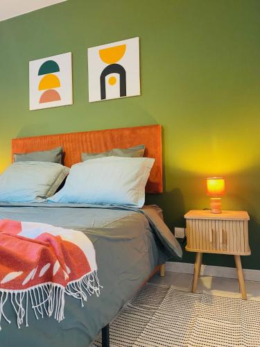 a bedroom with a bed and a green wall at La Perle - Jacuzzi - Wifi - Parking PV in Lunel