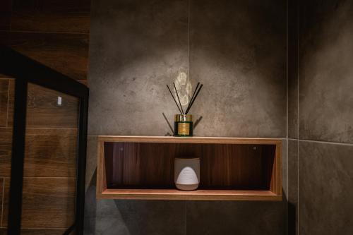 a shelf with a vase on it in a bathroom at Apartman Boutique Arandjelovac in Arandjelovac