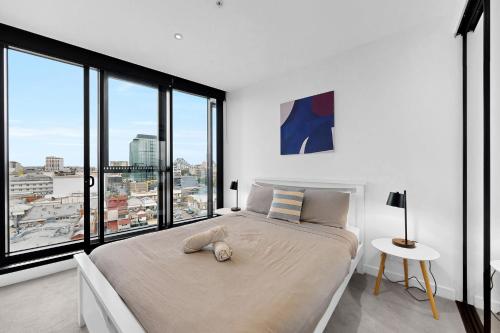 a bedroom with a large bed and large windows at Stylish 2BR with Story Bridge & Fireworks Views in Brisbane