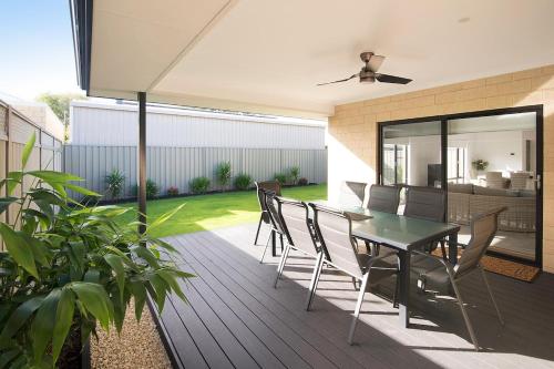 a patio with a table and chairs on a deck at Makin Memories Ducted heating cooling, WIFI, PS4 in Busselton