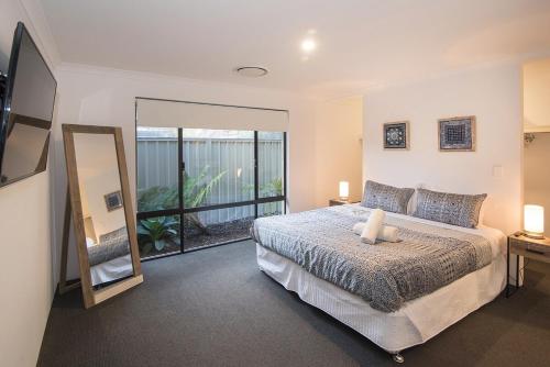 a bedroom with a bed and a large mirror at Makin Memories Ducted heating cooling, WIFI, PS4 in Busselton