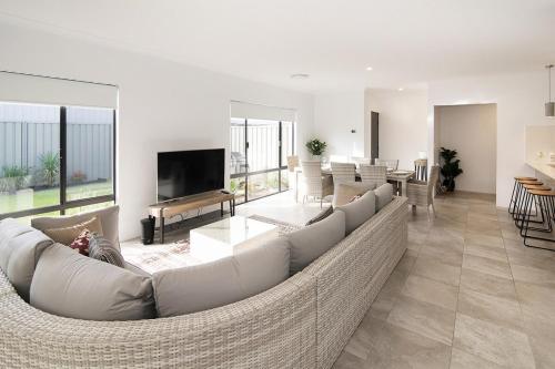 a living room with a large couch and a television at Makin Memories Ducted heating cooling, WIFI, PS4 in Busselton