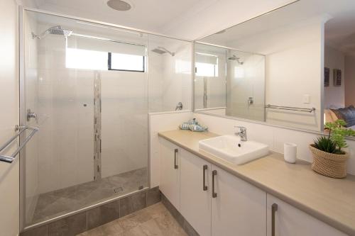 a white bathroom with a sink and a shower at Makin Memories Ducted heating cooling, WIFI, PS4 in Busselton
