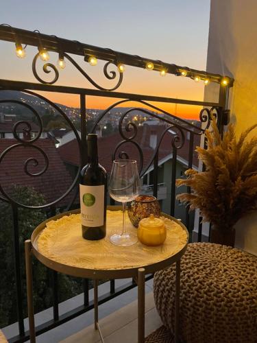 a bottle of wine and a glass on a table on a balcony at Apartman Boutique Arandjelovac in Arandjelovac