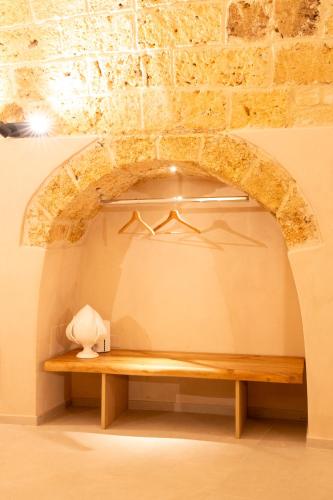 a room with a wooden bench in front of a brick wall at Tinè Bed & Relax in Gioia del Colle