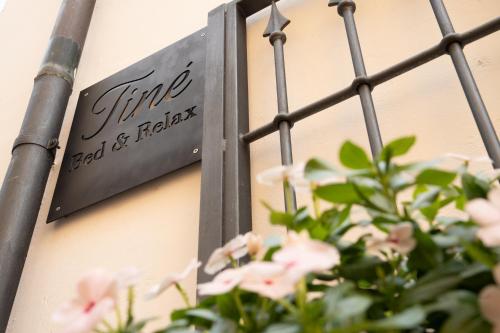 a sign on the side of a building with pink flowers at Tinè Bed & Relax in Gioia del Colle