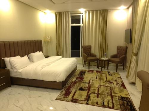 a hotel room with a bed and a table and chairs at Water Rocks Naran in Nārān