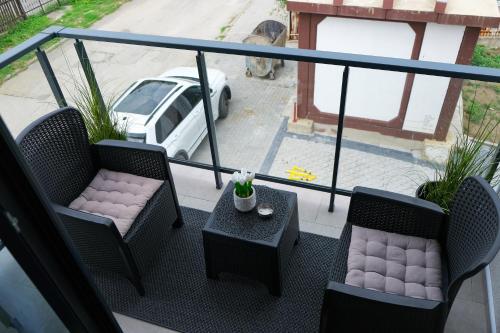 - un balcon avec deux chaises, une table et une voiture dans l'établissement Studio 83, à Požega