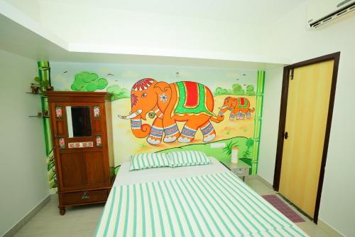 a bedroom with a mural of an elephant on the wall at La Maison Radha in Puducherry