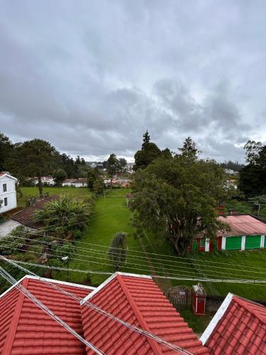 a view of a village with red roofs at Shivv's Leisure in Ooty