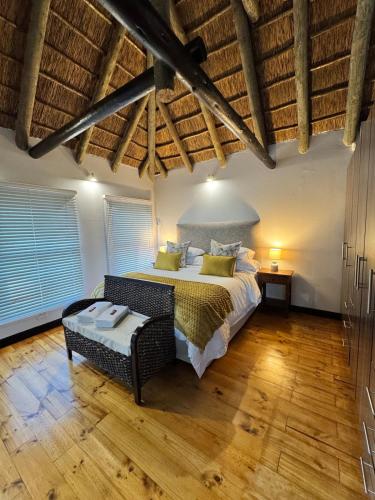 a bedroom with a large bed and a wooden floor at The Whispering Milkwood Cottage in Gqeberha