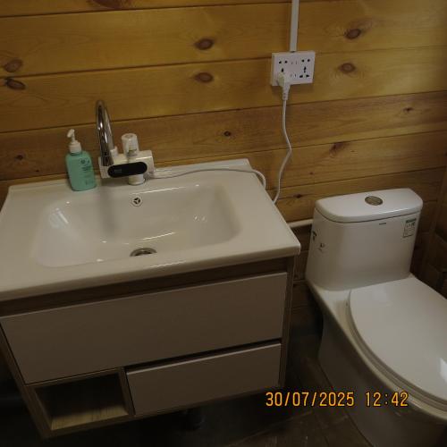 a bathroom with a white sink and a toilet at Bright Terelj Family Camp in Dugang Süme