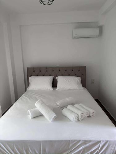 a white bed with three rolled towels on it at Xenia's Resorts in Ofrínion