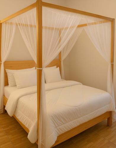 two beds in a bedroom with white sheets and drapes at 2BR Morden Apartment Near Soroti Flying Sch - A3 in Soroti