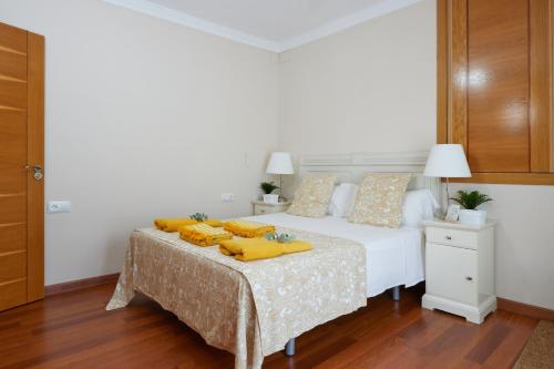 a bedroom with a bed with yellow pillows on it at Hevres El Capricho in Málaga